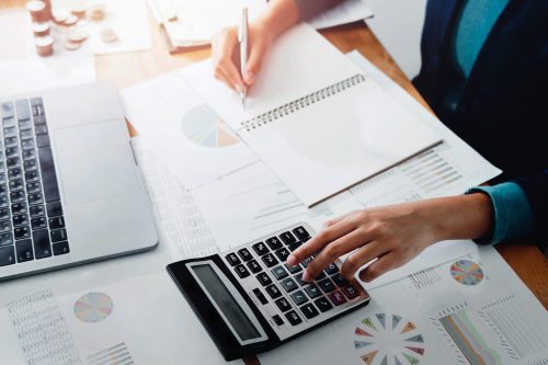 businesswoman working in office with using a calculator to calculate the numbers finance accounting concept